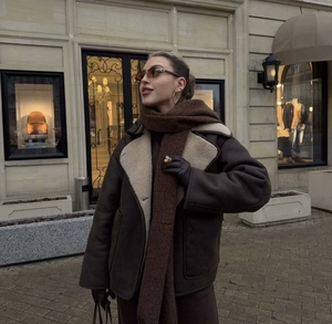 Detail of dark brown faux shearling jacket with large collar and cream wool lining