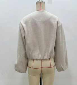 Détail de l'ourlet côtelé et du dos d'un blouson aviateur en maille beige doux