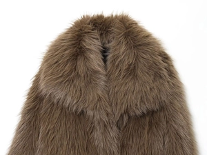 Gros plan détaillé sur la texture en fausse fourrure marron et le large revers du manteau