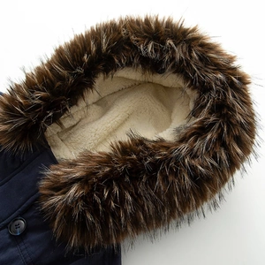 Detail of detachable faux fur collar and warm lamb wool lining on navy parka coat