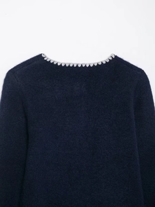 Detail of navy knit sweater showing soft mohair texture and grey scalloped neckline trim