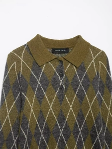Detailed close-up of the polo collar and dark buttons on an argyle knit sweater