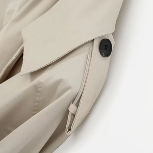 Detail of British style beige trench coat collar with shoulder straps and dark buttons