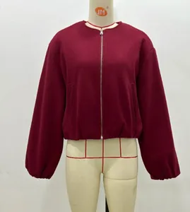 Detail of burgundy cropped jacket with crew neck and silver metal zipper closure