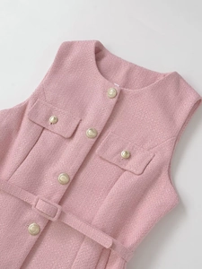 Close-up of pink tweed vest featuring gold buttons and a matching waist belt