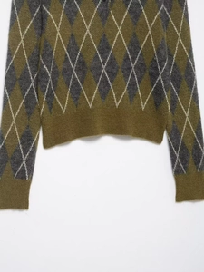 Detail of diamond pattern knit sweater showing olive and charcoal wool texture