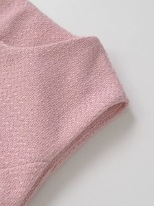 Close-up of pink tweed fabric texture and stitching detail on women's vest