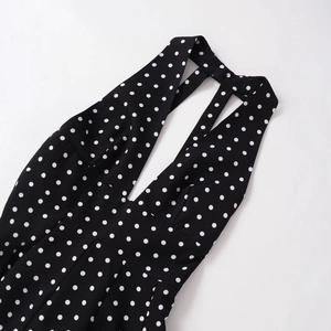 Slim fit V-neck halter dress featuring black and white polka dots and cross back straps