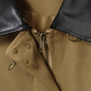 Workwear jacket featuring a khaki canvas body and a contrasting black leather collar detail