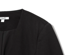 Vue détaillée de l'épaulette du blazer noir avec doublure lisse et étiquette blanche