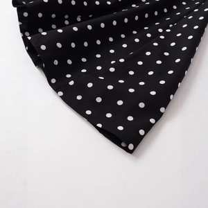 Slim fit V-neck halter dress featuring a classic black and white polka dot pattern design