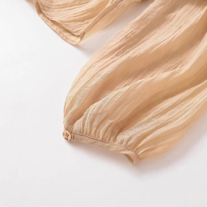 Women's apricot pleated translucent shirt featuring cuffed sleeves with button detail