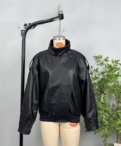 Detailed close-up of a vintage black faux leather jacket with stand collar and epaulets