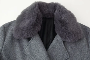 Detail of gray wool coat featuring a plush faux fur collar and textured tweed fabric