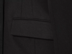 Vue détaillée d'une veste de tailleur noire en sergé avec poche à rabat et coutures précises