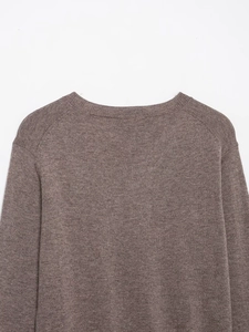 Detail of taupe knit sweater showing the ribbed round neckline and shoulder stitching