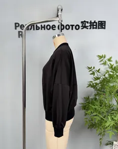 Détail d'un sweat-shirt noir à manches longues avec poignets côtelés et col rond