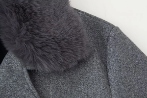 Detailed view of the dark grey wool jacket featuring a fluffy faux fur collar and textured fabric