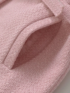 Macro detail of pink tweed fabric texture with pocket stitching and silk lining