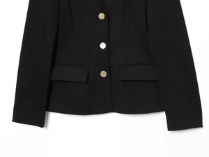 Vue détaillée du blazer noir pour femme avec boutons dorés et poches à rabat