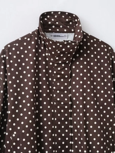Detailansicht des braunen Polka-Dot-Jackenkragens mit Stehkragen und hochwertigem Etikett