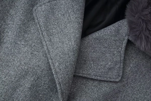 Detailed close-up of dark grey wool blend fabric texture and soft faux fur collar