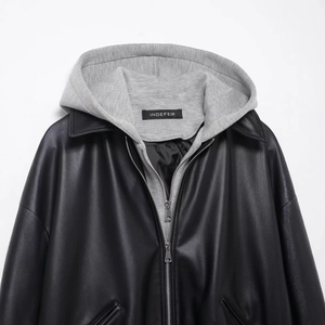 Black leather jacket with grey knit hood and silver zipper in a layered style