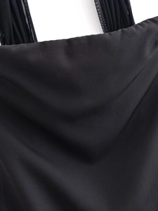 Detail shot of black satin dress featuring a cowl neck design and sheer mesh shoulder straps