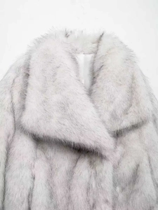 Gros plan détaillé sur la texture de fourrure synthétique d'un manteau blanc à col large