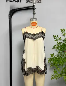 Detail of elegant ivory satin camisole featuring delicate black floral lace trimming