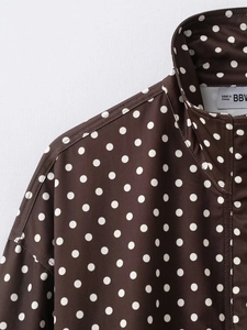 Detail des klassischen Polka-Dot-Musters und der Köperstruktur auf brauner Kragenjacke