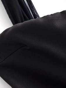 Detailed macro view showing the fine black fabric texture and mesh stitching on the dress