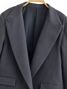 Detail of classic peak lapel and breast pocket on dark grey premium business blazer