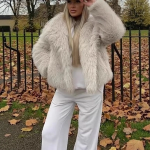 Chic manteau en fausse fourrure beige à grands revers dans un décor extérieur d'automne