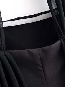 Detail of black patchwork dress showing fine mesh texture and stitching quality