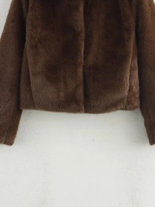 Close-up detail of smooth dark brown faux fur texture on fashionable women coat