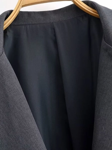 Detailed close-up of grey textured suit lapel with smooth black silk inner lining