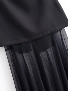 Detail of black fabric stitched with transparent pleated mesh on a tube dress