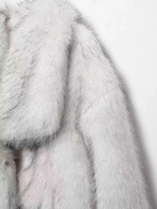 Détail macro de la texture longue et duveteuse d'un manteau en fausse fourrure dégradée