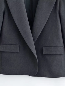 Detailed view of the dark grey suit blazer featuring peaked lapels and a flap pocket