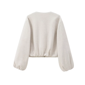 Rear view of cream short jacket showing puff sleeves and elasticated hem details