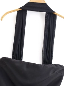 Detail of a black halter neck dress with mesh straps on a wooden hanger