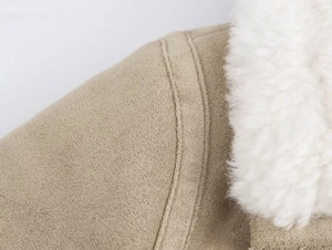 Detail of khaki faux suede jacket with soft white shearling lining and neat double stitching