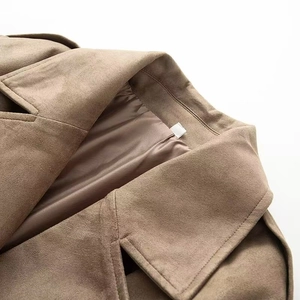 Dettaglio macro del bavero di un trench in pelle scamosciata kaki con cuciture premium