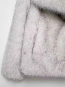 Gros plan sur la texture en fausse fourrure du manteau gris clair à poils longs