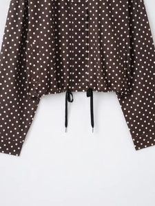 Detail der kaffeebraunen Polka-Dot-Jacke mit verstellbarem Kordelzug am Saum und Taschen