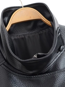 Close-up of vintage black faux leather jacket collar with zipper and button details