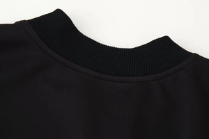 Vue détaillée du col côtelé d'une veste noire avec des coutures de haute qualité