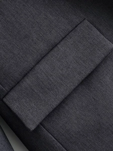 Detail view of deep gray suit jacket flap pocket with premium textured fabric and fine stitching