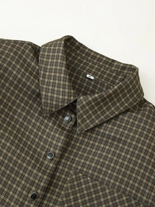Detail of checkered shirt collar with shoulder pads and size S tag on textured fabric